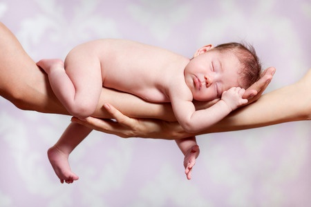 43870218 - newborn baby sleeping on parents hands, relax